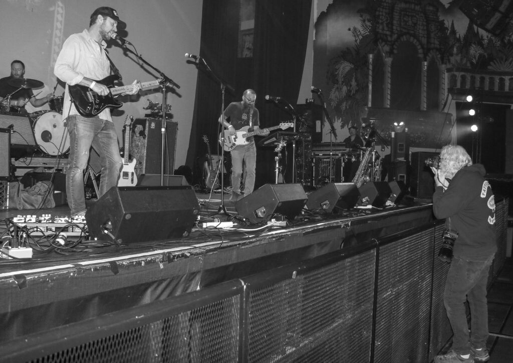 Concert photographer Michael McGrath takes pics at a show held in his honor in May 2025 at the Oriental Theatre. (John Moore/Denver Gazette)