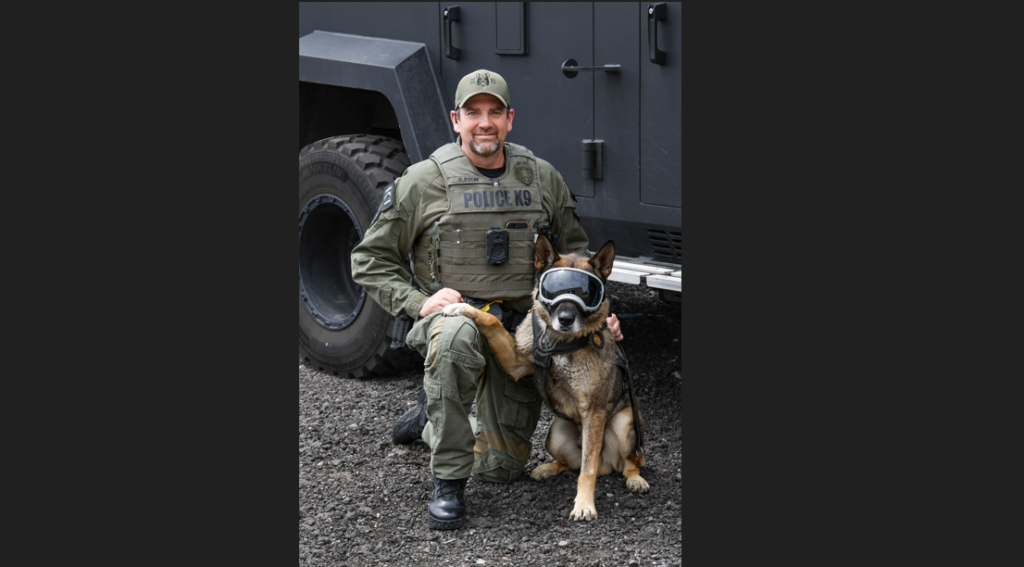 A photo of a man dressed in camouflage with a dog