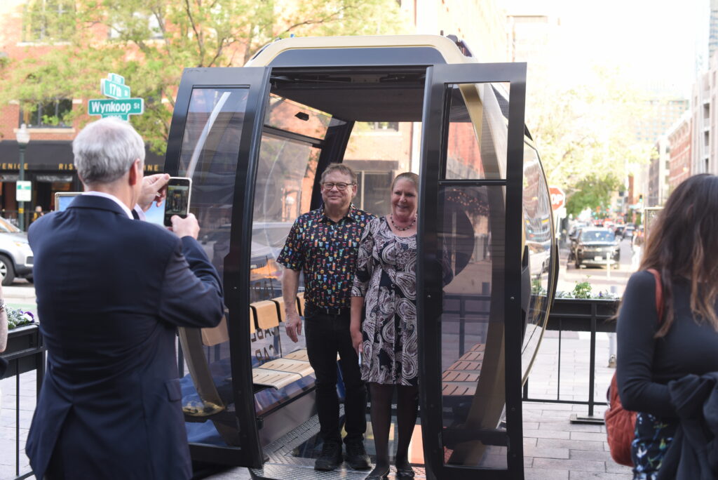 Two people stand inside a cable car