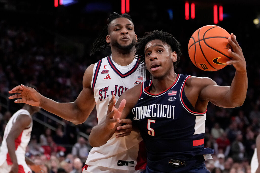 UConn forward Tarris Reed Jr. (5) attempts to drive past St. John's forward Zuby Ejiofor (24) during the second half of an NCAA college basketball game in the championship of the Big East tournament, Saturday, March 14, 2026, in New York. (AP Photo/Yuki Iwamura)