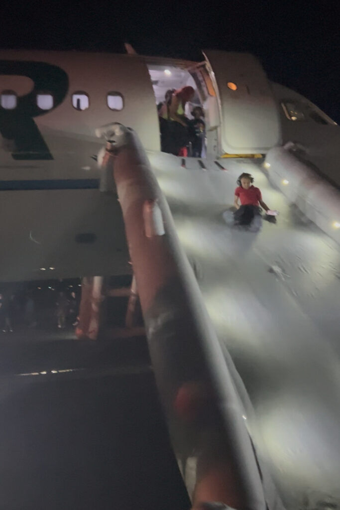 passengers evaxuateing a plane
