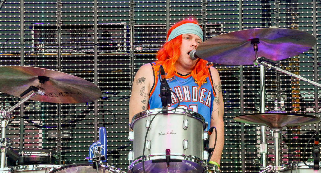 Flaming Lips drummer Matt Duckworth Kirksey sports an orange wig and an Oklahoma City Thunder jersey for the band's set at the Outside Days festival in Denver, May 30, 2026, on the Auraria campus. At the same time, the Thunder were losing a Game 7 playoff game to the San Antonio Spurs. (John Moore/Denver Gazette)