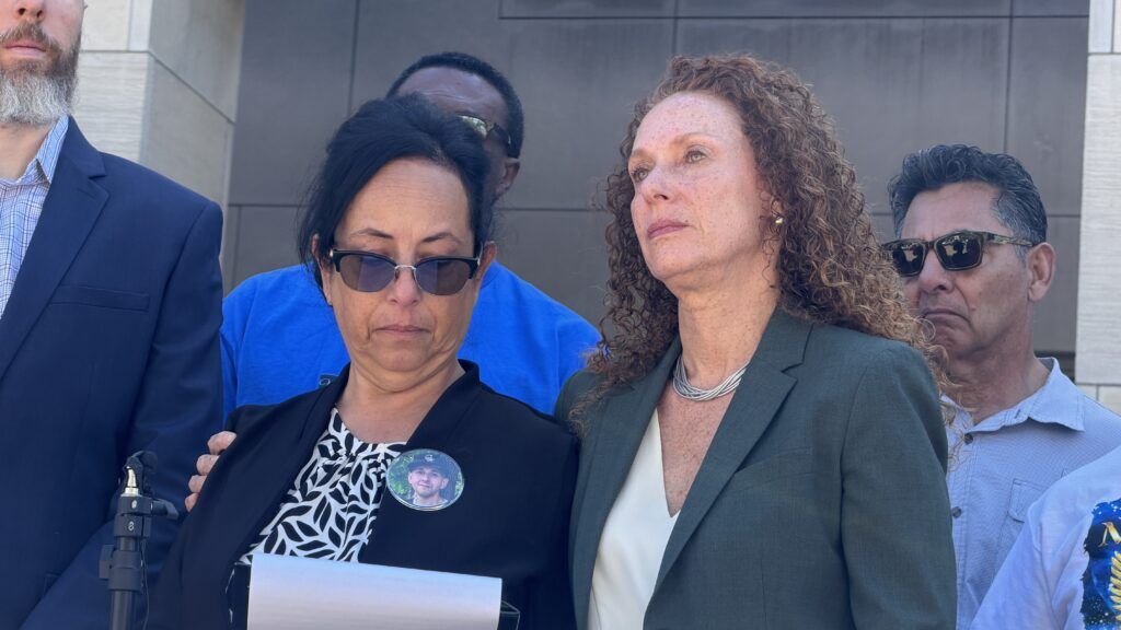 two women standing in a crowd in front of a government building