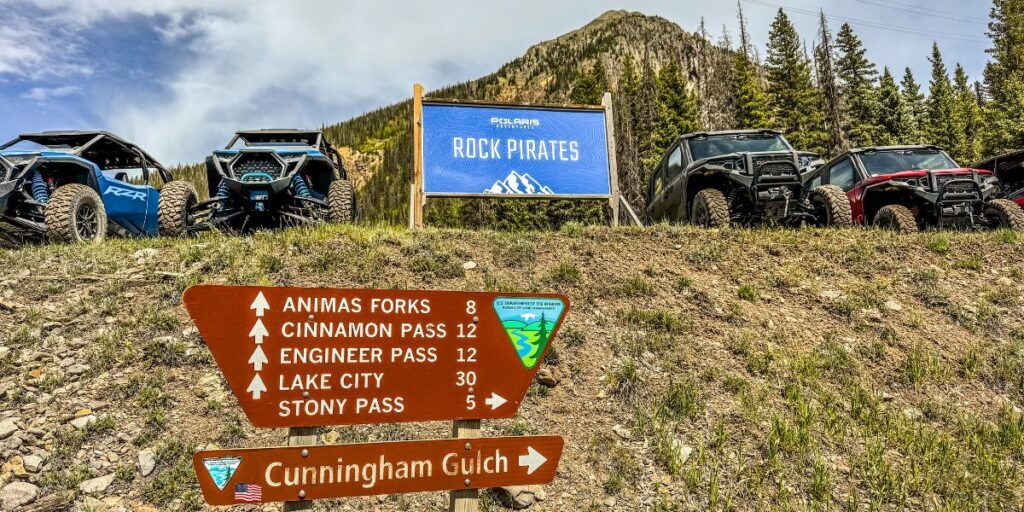 Rock Pirates Backcountry Adventures sign surrounded by vehicles.