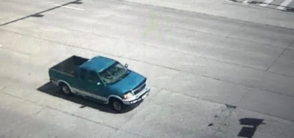 A photo of a blue pickup truck on a road