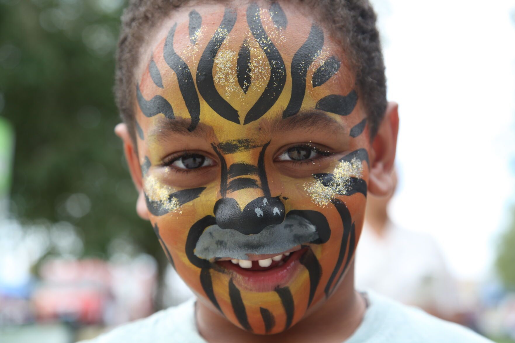 A child grins with face paint at 2022 Global Fest in Aurora.