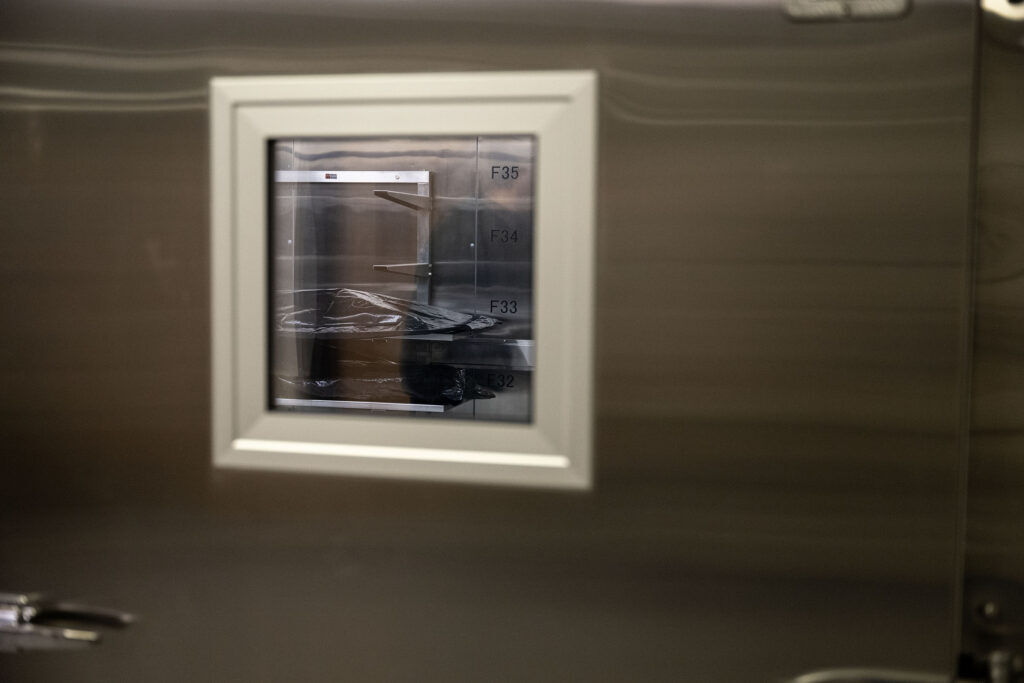 A body bag, digitally altered to remove identifying information, lies in a fridge at the Medical Examiner’s office on Thursday, May 21, 2026.