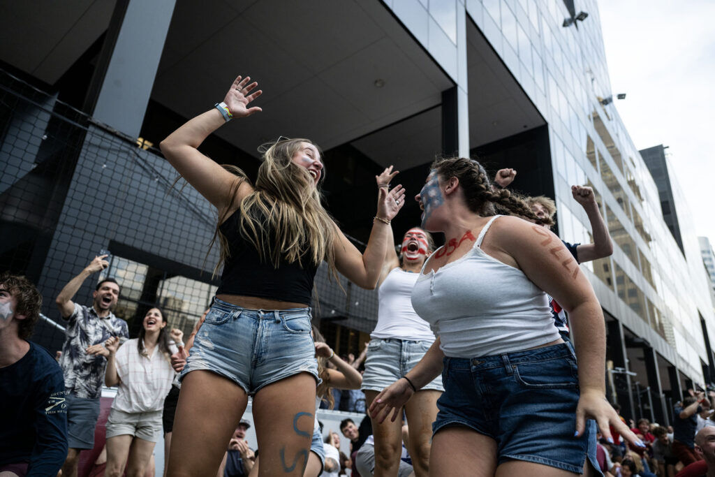 Maddy McInturff, left, and her friends Esther Sage and Kezi Davidson celebrate the first USA goal during a watch party for the USA vs Bosnia-Herzegovina game at Skyline Park on Wednesday, July 1, 2026.