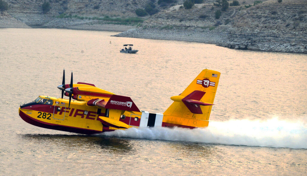 A Bridger Aerospace Tanker skims along the surface of the Pueblo Reservoir to scoop up water to drop on the northern face of the Aspen Acres Fire on Sunday, July 5, 2026. (The Gazette, Jerilee Bennett)