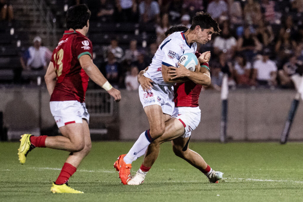 USA Fly Half Christopher Hilsenbeck is tackled by the Portugal defense during the USA vs Portugal game at the Rugby World Nations Cup at Dicks Sporting Goods Park on Saturday, July 4, 2026. USA won the match 30-29.