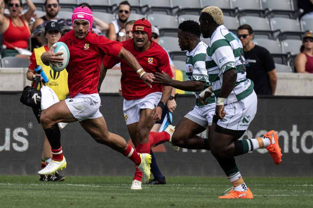 Tonga outsid eCenter John Tapueluela pushes past the Zimbabwe defense during the first half of Tonga vs Zimbabwe at the Rugby World Nations Cup at Dicks Sporting Goods Park on Saturday, July 4, 2026.