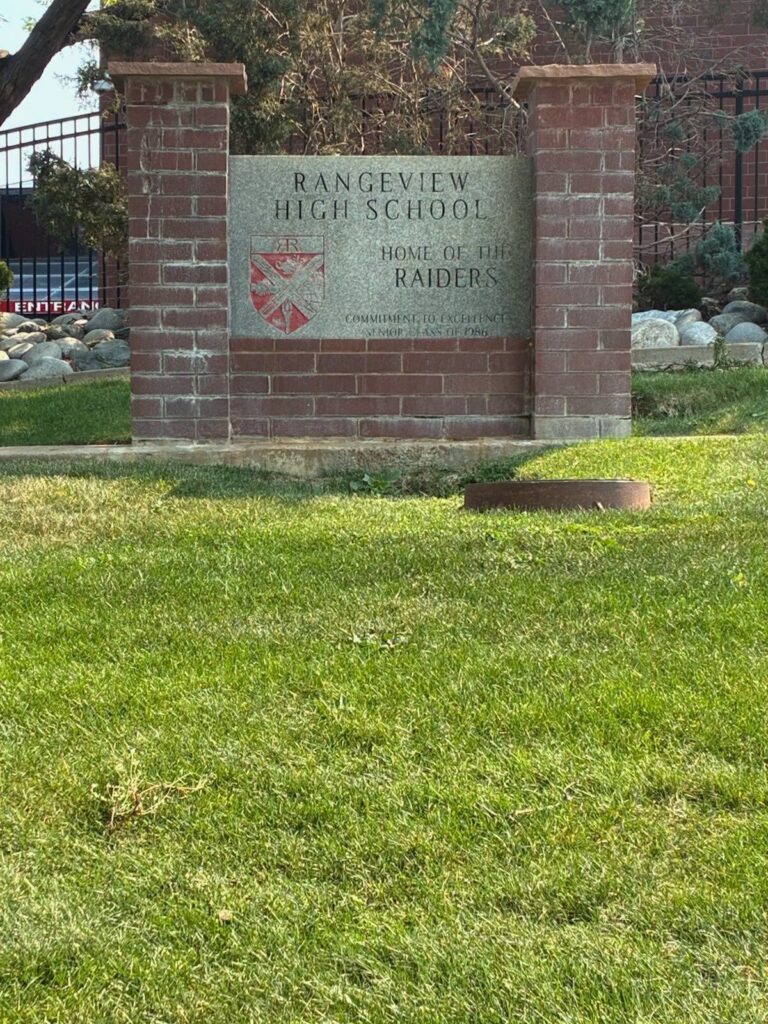 Green grass in front of a Rangeview High School sign.