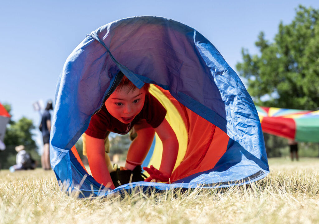 Padraig Monaghan, 6, crawls through an obstacle course during a Youth Sports Day clinic for special olympics young athletes on Friday, July 10, 2026. Athletes learned basketball, street hockey, soccer, lacrosse, and dance during the event.