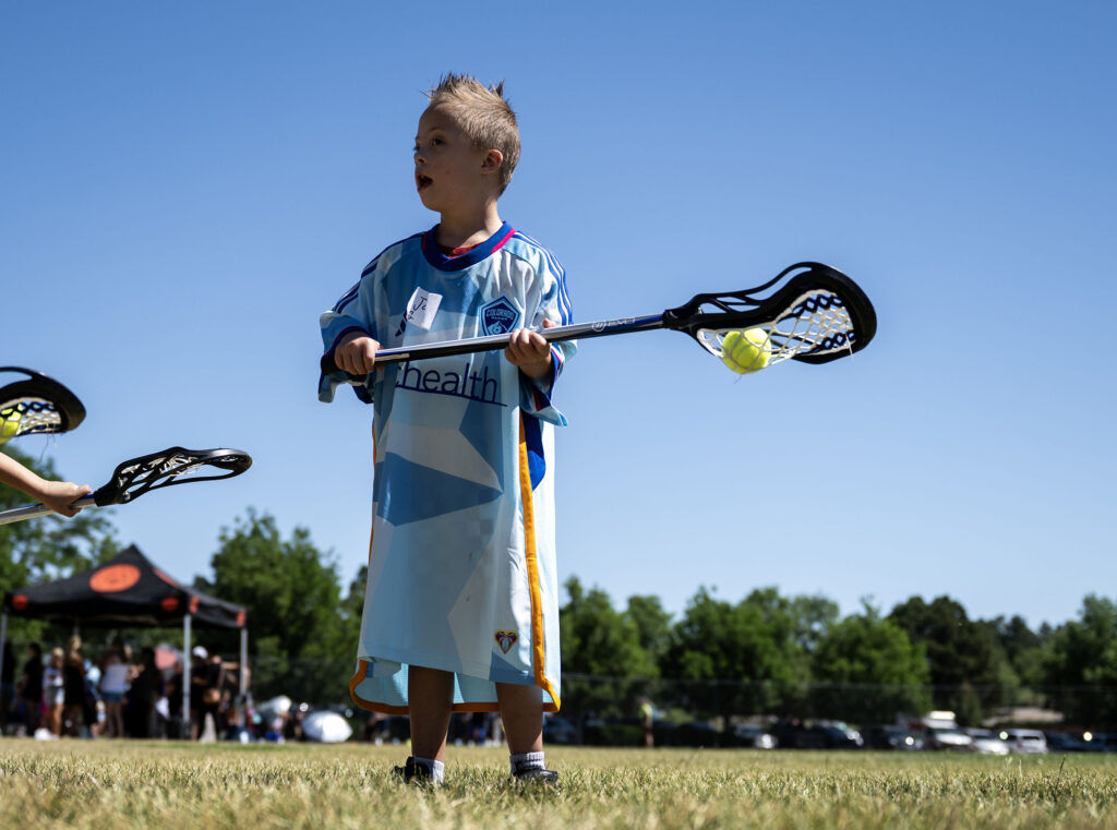 Jaxson Leeper, 7, learns how to play lacrosse during a Youth Sports Day clinic for special olympics young athletes on Friday, July 10, 2026. Athletes learned basketball, street hockey, soccer, lacrosse, and dance during the event.