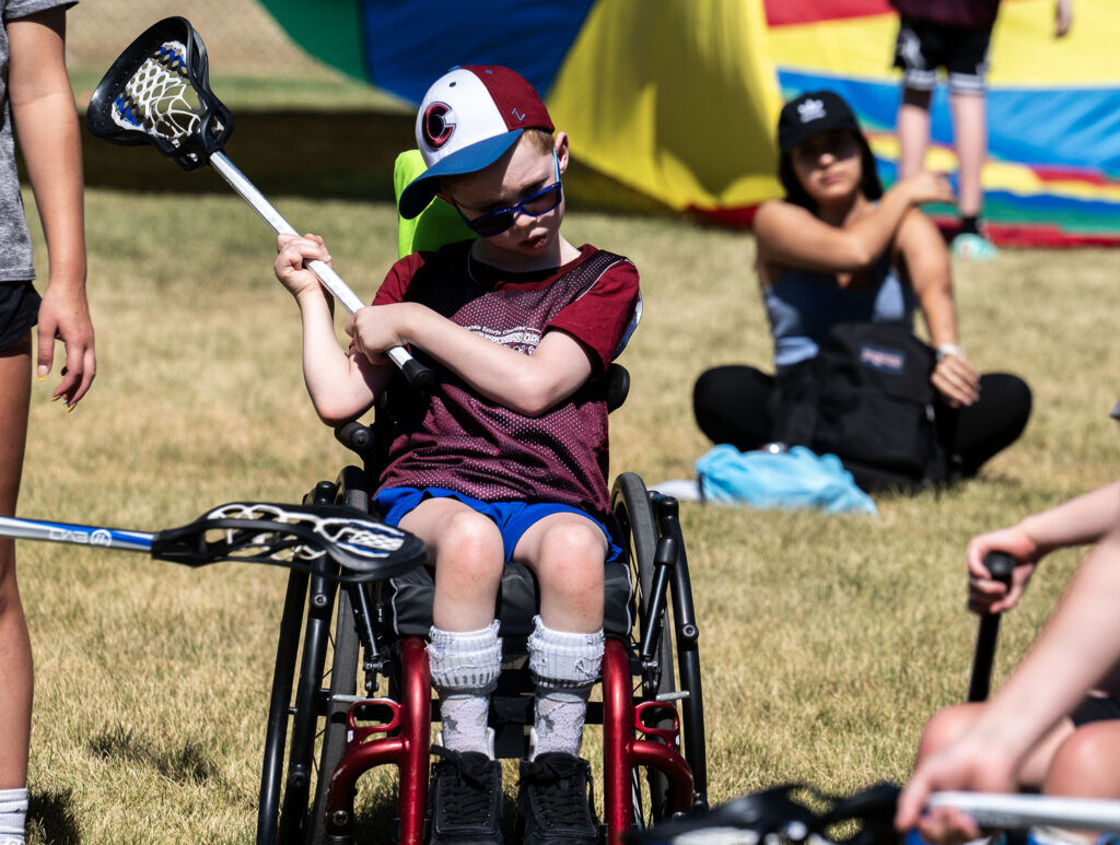 James Turk, 8, learns how to play lacrosse during a Youth Sports Day clinic for special olympics young athletes on Friday, July 10, 2026. Athletes learned basketball, street hockey, soccer, lacrosse, and dance during the event.