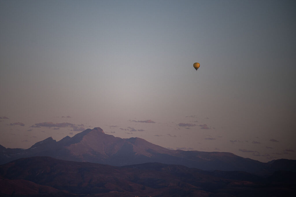 A balloon flies in the early morning light near Longs Peak during the Erie Balloon Festival on Saturday, July 11, 2026.