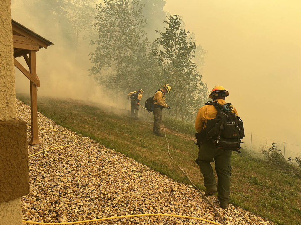 Volunteer with the Southern Colorado Interagency Wildland Fire Team, including Amanda Wood, and firefighters from Fort Carson work on "prep and hold" structure protection during the Aspen Acres fire, July 1. Photo courtesy of Amanda Wood.