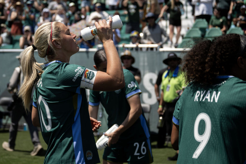 Summit FC Midfielder Lindsey Heaps (10) drinks water by the Denver Summit FC bench before the start of Summit FC’s first game at Centennial Stadium on Saturday, July 18, 2026. Summit won their game against Portland Thorns FC 2-1.
