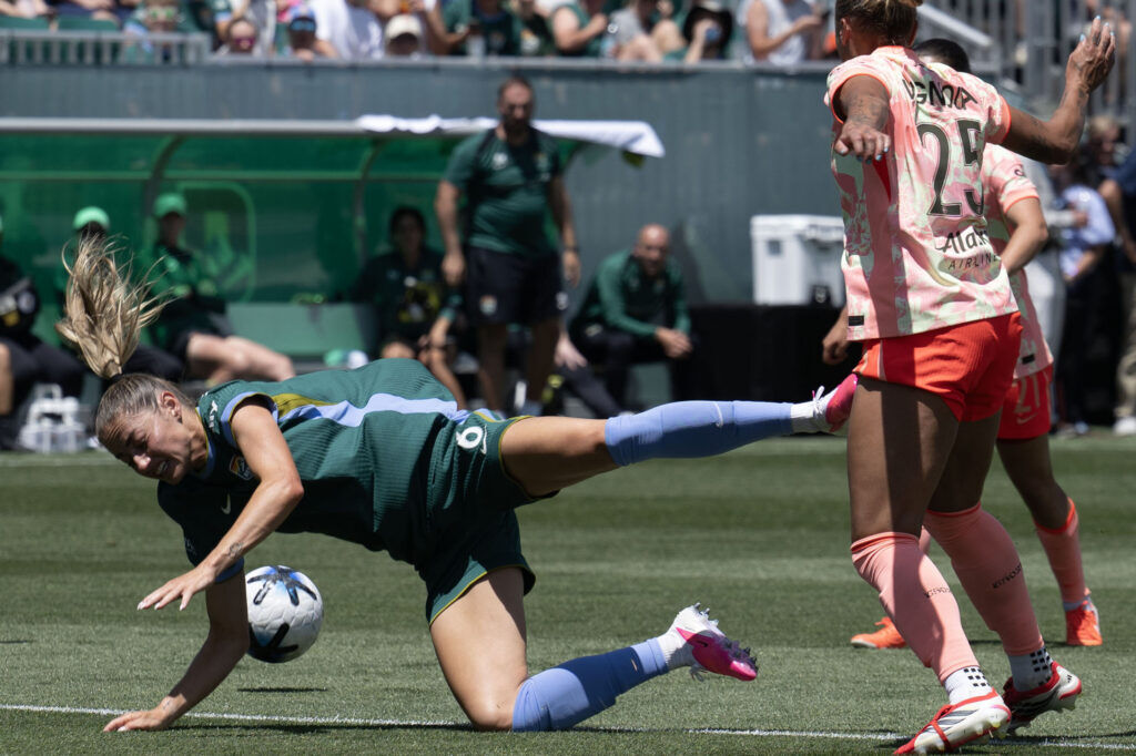 Denver Summit FC forward Janine Sonis (6) falls over the leg of Portland Thorns FC defender M.A. Vignola (25) as they fight over the ball in the first half of Summit FC’s first game at Centennial Stadium on Saturday, July 18, 2026. Summit won 2-1.