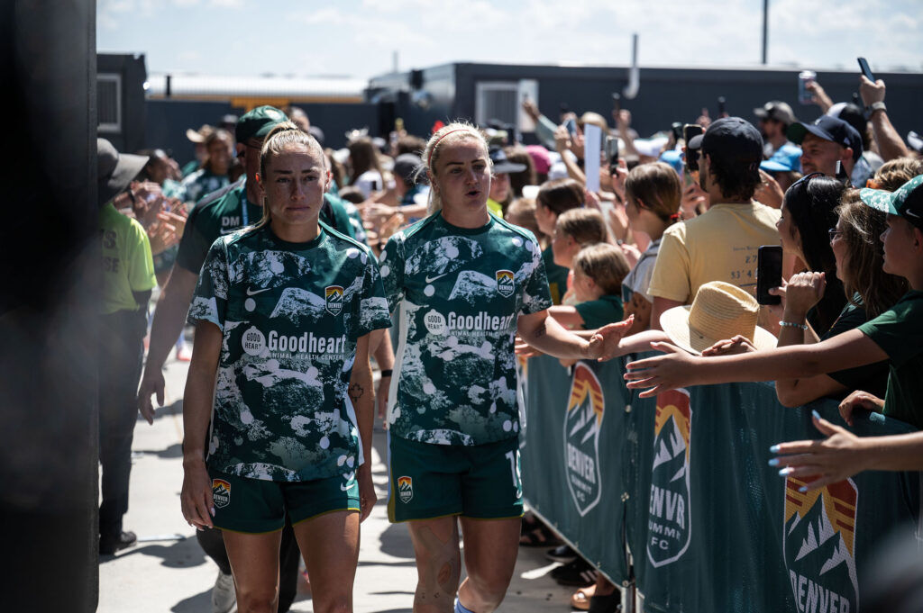 Summit FC co Captains Janine Sonis, left, and Lindsey Heaps lead the team past a crowd of fans as they make their way into the brand new Centennial Stadium before their home match against Portland Thorns on Saturday, July 18, 2026.