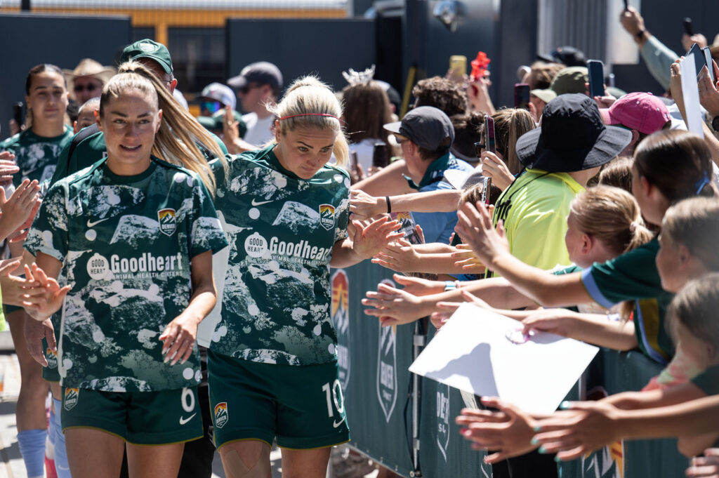 Summit FC co Captains Janine Sonis, left, and Lindsey Heaps lead the team past a crowd of fans as they make their way into the brand new Centennial Stadium before their home match against Portland Thorns on Saturday, July 18, 2026.