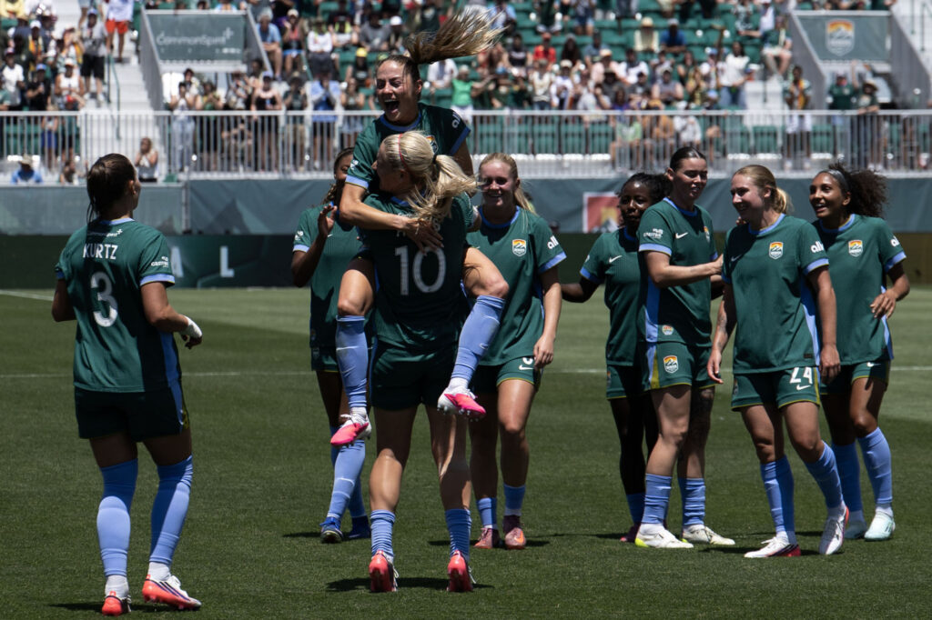 Denver Summit FC defender Kaleigh Kurtz (3) jumps into the arms of Summit Midfielder Lindsey Heaps (10) as they celebrate their first goal in the final minutes of the first half during the Summit FC’s first game at Centennial Stadium against the Portland Thorns on Saturday, July 18, 2026. Summit won 2-1.
