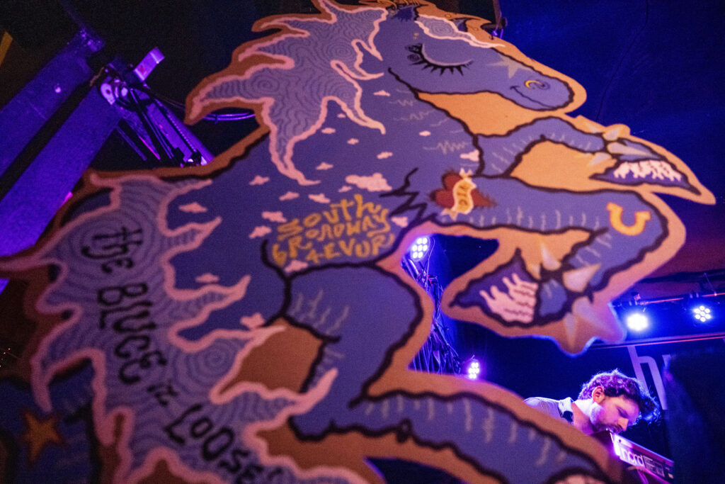 A poster of Blucifer hangs on the stage at the Hi-Dive as Honey Blazer performs on the first night of Blucifer’s First Rodeo on South Broadway on Friday, July 24, 2026.