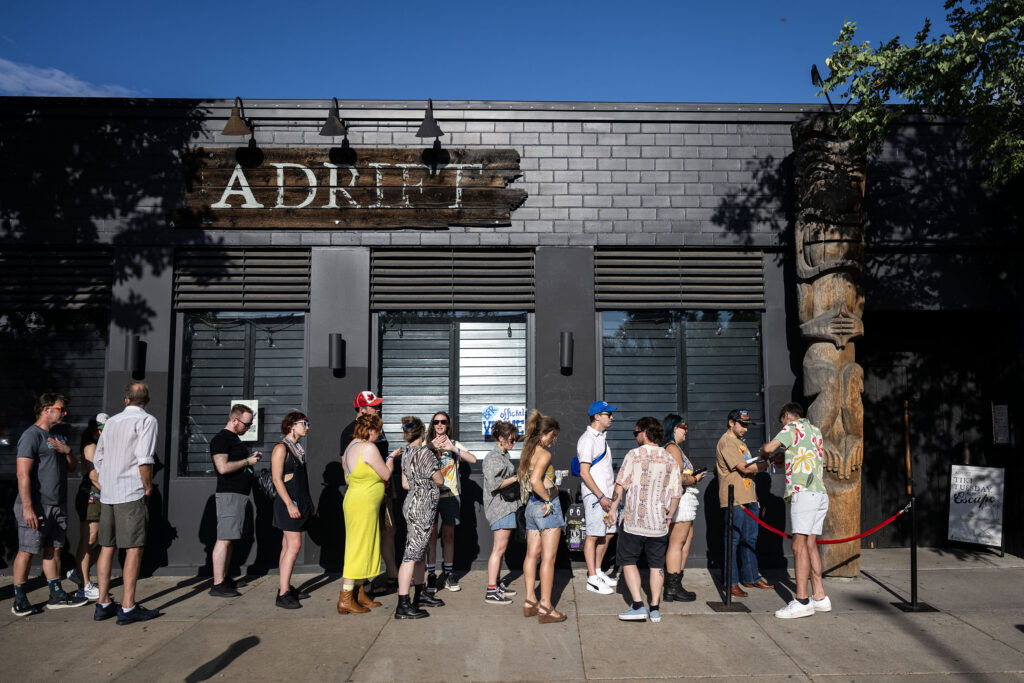 People wait in line outside Adrift Tiki Bar for a show on the second night of Blucifer’s First Rodeo, a music festival on South Broadway, on Saturday, July 25, 2026.