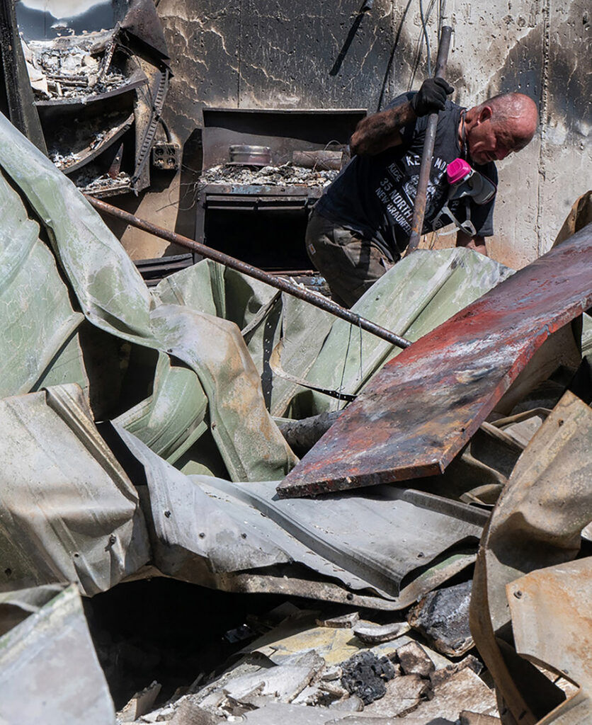 A man named Paul digs through what used to be the kitchen in his home that he lost in the Aspen Acres Fire on Tuesday, July 21, 2026. The home is off of Pine Dr. in Beluah. (The Gazette, Jerilee Bennett)