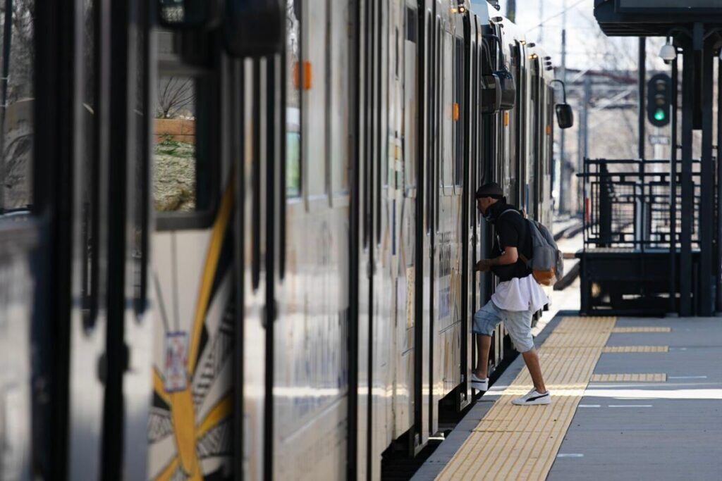 A passenger boards an RTD train at the Perry Station (copy)
