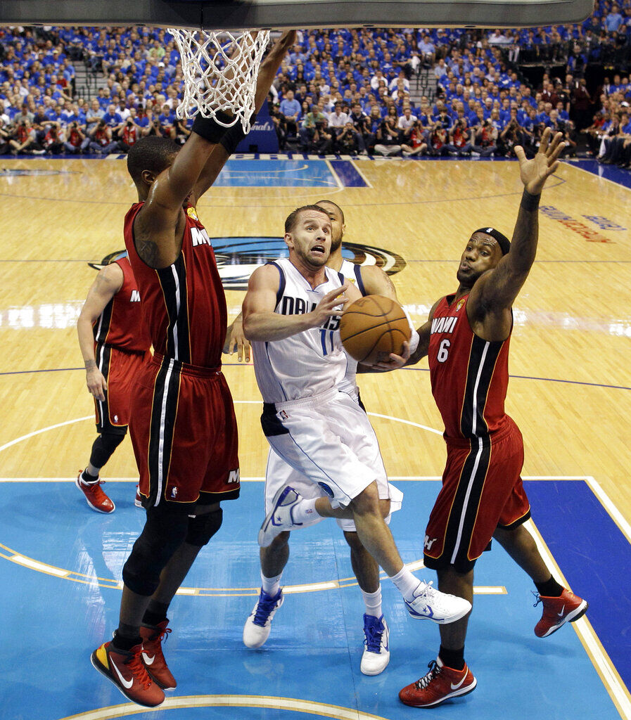 Dallas Mavericks' Jose Juan Barea (11) shoots between Miami Heat's Chris Bosh and LeBron James (6) during the first half of Game 4 of the NBA Finals basketball game Tuesday, June 7, 2011, in Dallas. (AP Photo/David J. Phillip; Pool)