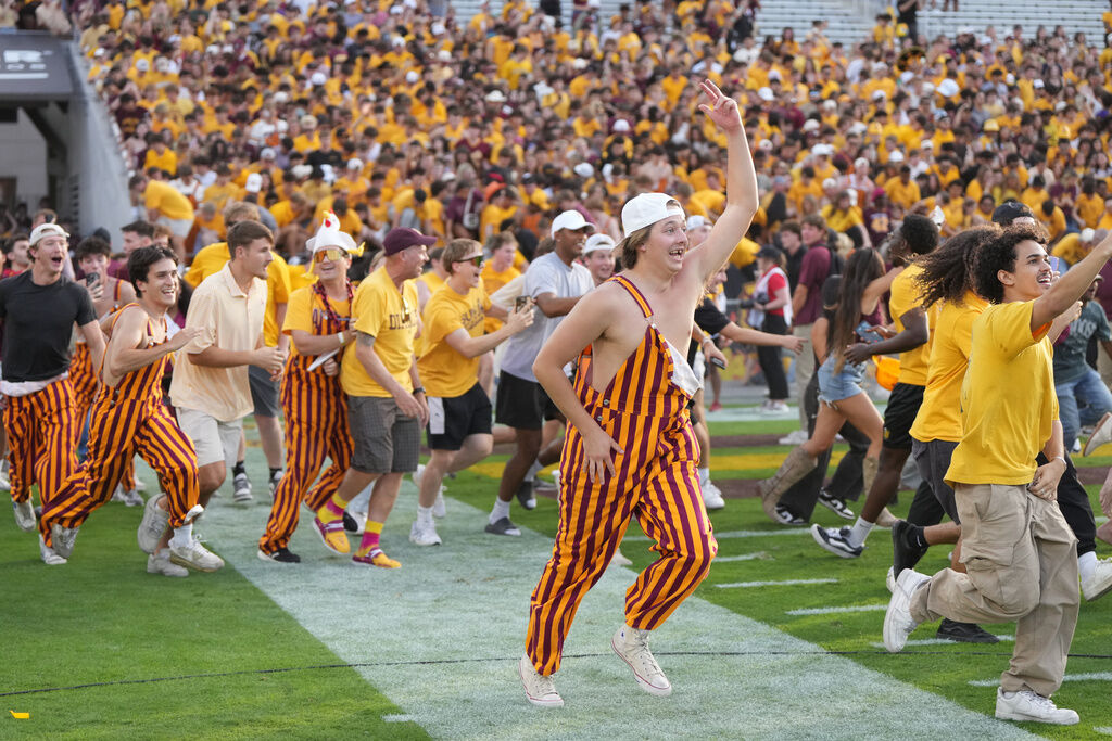 Arizona State fans rush the field after defeating Texas Tech during an NCAA college football game Saturday, Oct. 18, 2025, in Tempe, Ariz. (AP Photo/Rick Scuteri)