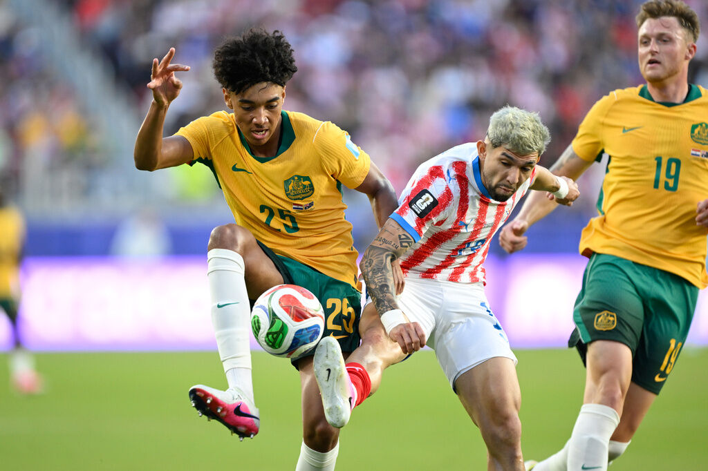 Australia's Lucas Herrington (25) battles for the ball with Paraguay's Julio Enciso (19) during the World Cup Group D soccer match between Paraguay and Australia in Santa Clara, Calif., near San Francisco, Thursday, June 25, 2026. (AP Photo/Eakin Howard)