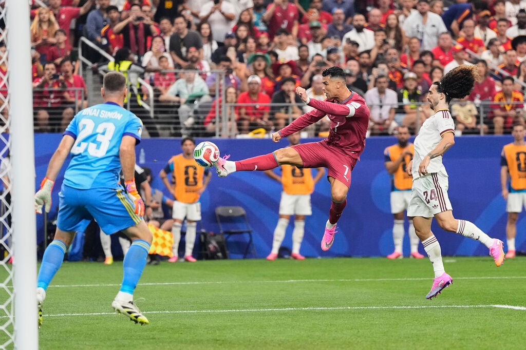 Portugal's Cristiano Ronaldo (7) shoots against Spain goalkeeper Unai Simon (23) during the World Cup round of 16 soccer match in Arlington, Texas, near Dallas, Monday, July 6, 2026. (AP Photo/Ashley Landis)
