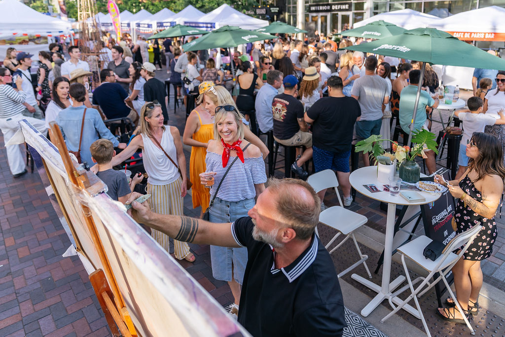 Visitors watch an artist paint at Denver French Fest in Cherry Creek. (Photo courtesy of Cherry Creek North)