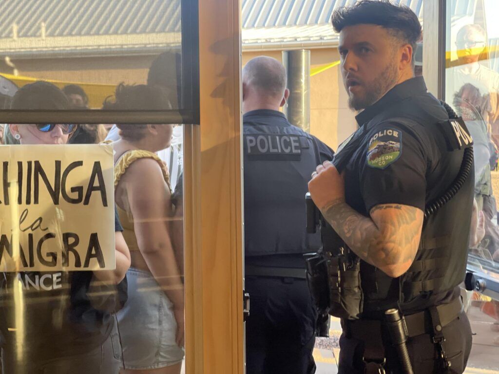 Police officers walk into a crowd of protesters
