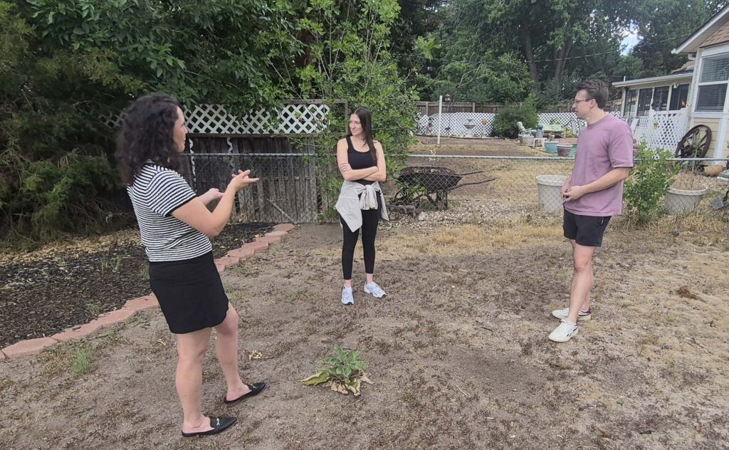 Agent Tori Worthing works with buyers in the backyard of a home in Virginia Village, weighing its interior appeal against issues in the yard. (Denver Gazette, Mark Samuelson)
