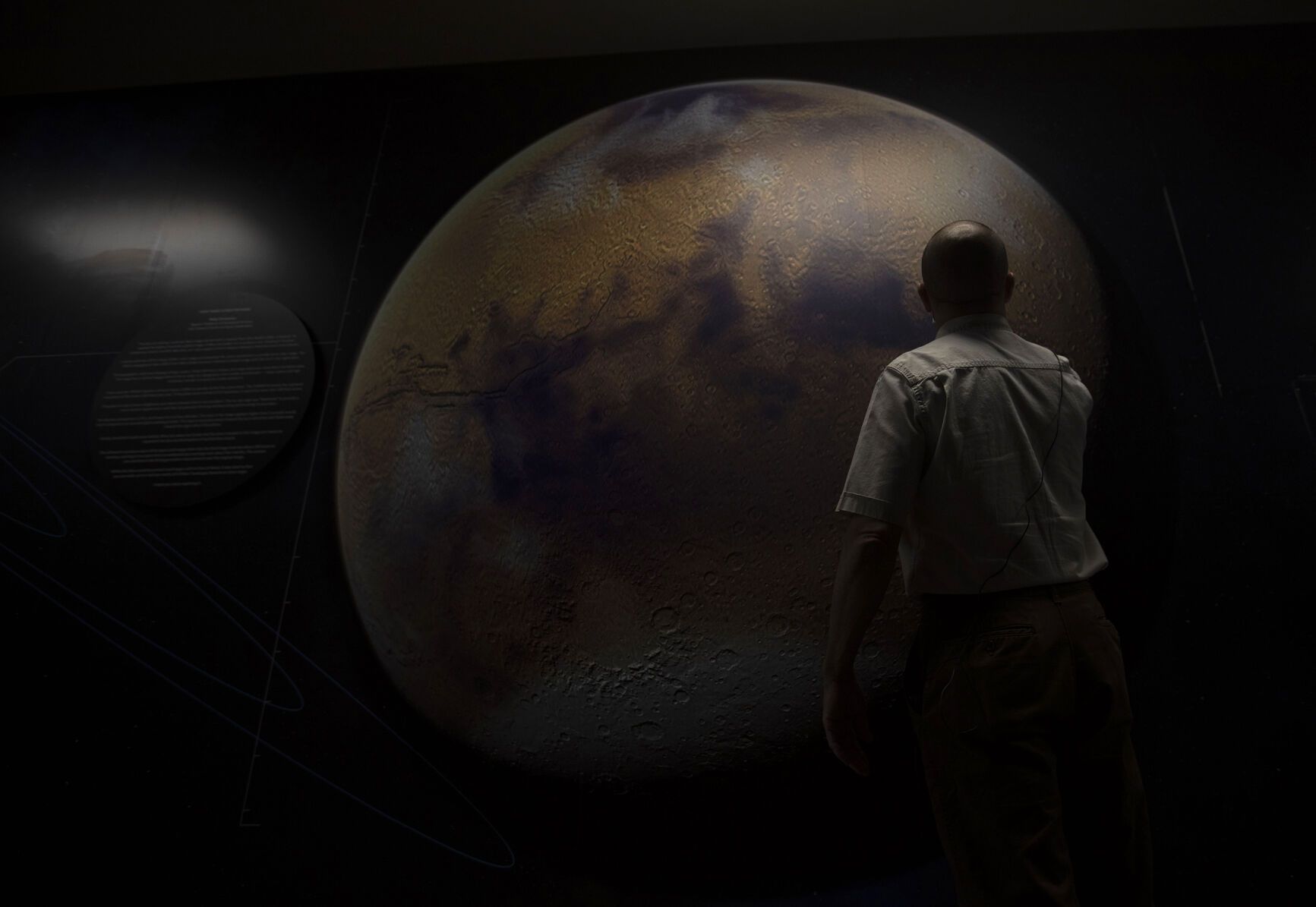 Aeroshell principal engineer Dave Scholz views a photo of Mars