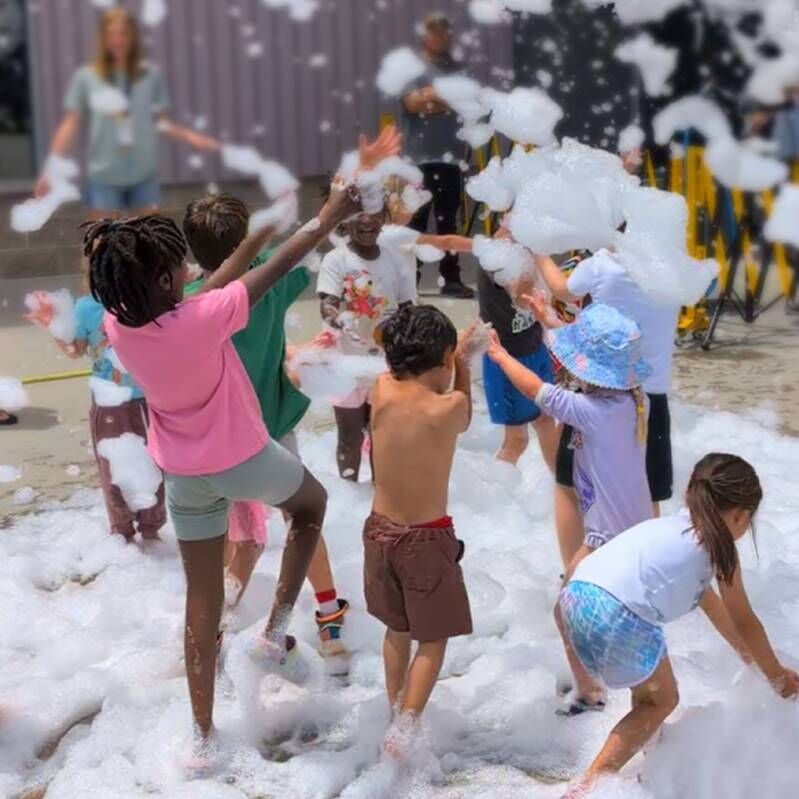 Children seen playing in bubbles at the Mess Fest hosted by the Children's Musuem of Denver.