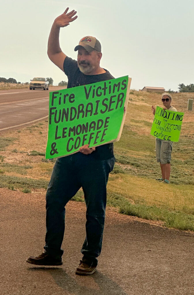 A man holds a lemonade sign.